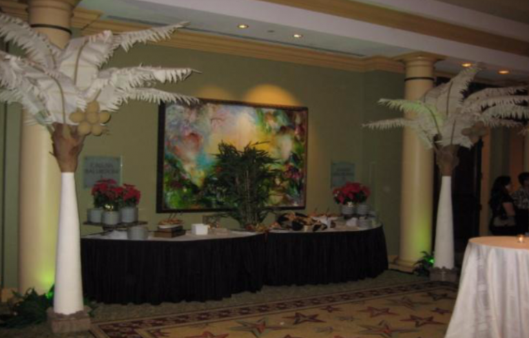 A room with palm trees and a painting on the wall