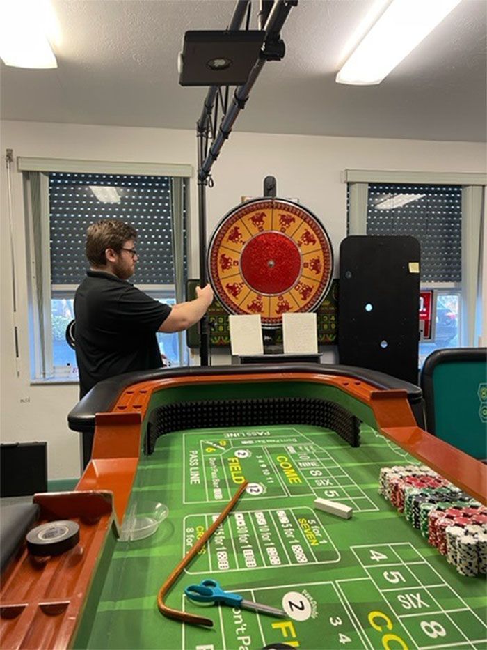 A man is working on a roulette table in a casino