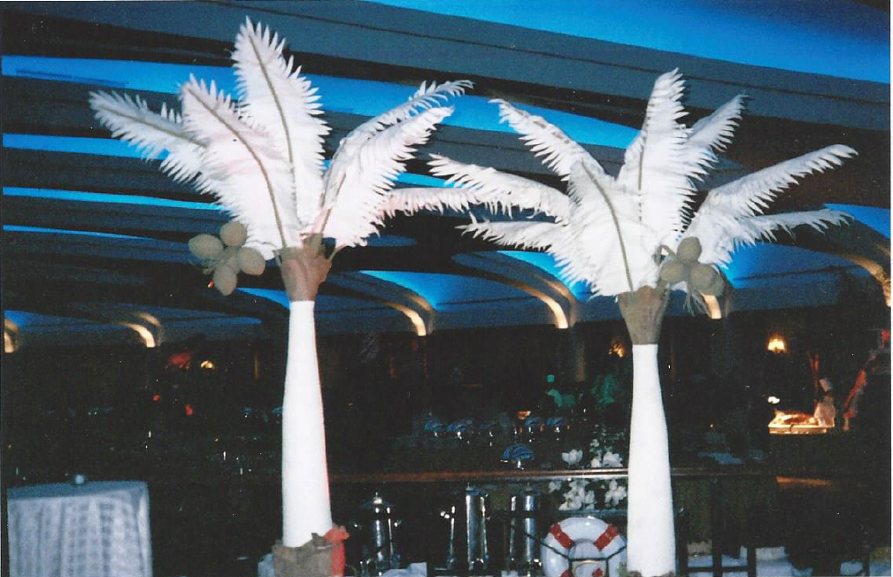 Two tall white palm trees in a dark room