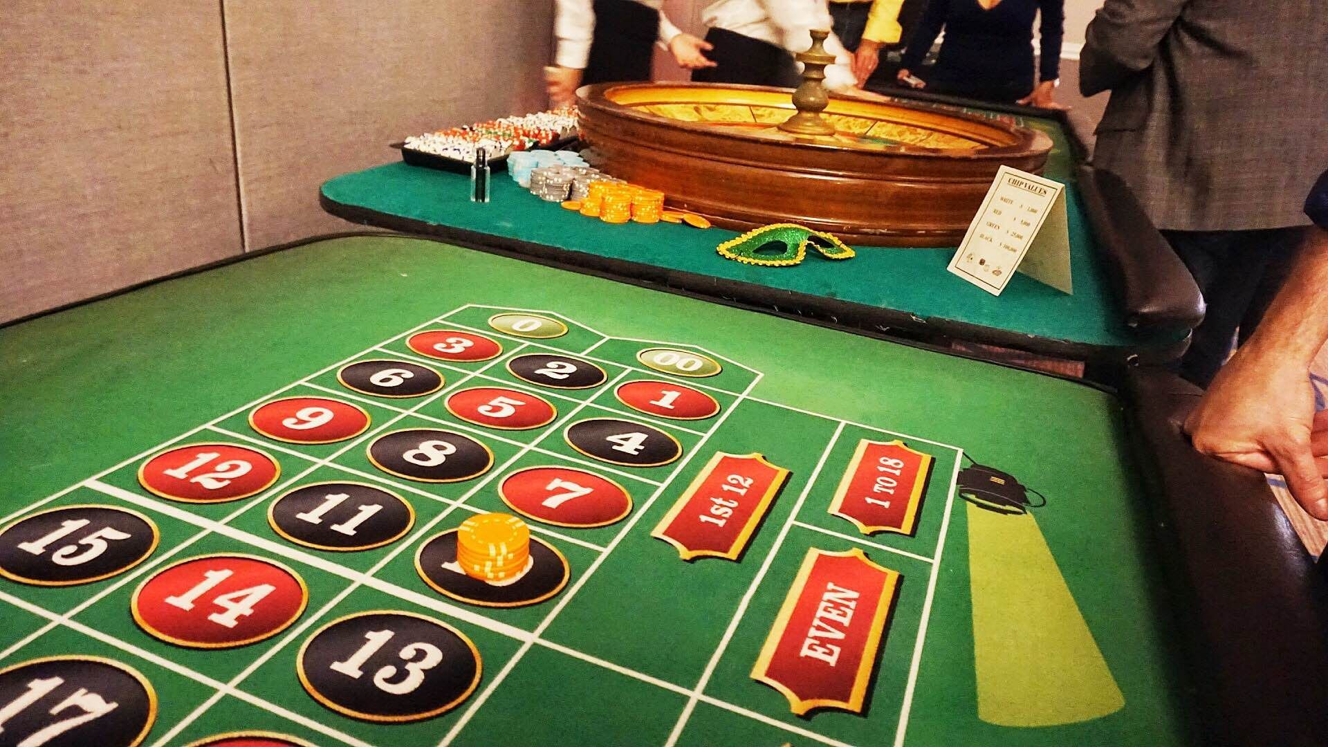 A group of people are playing roulette on a green table