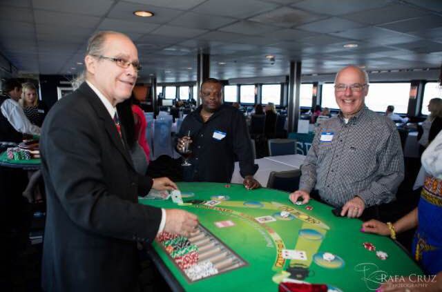 A man in a suit is playing a game of poker at a table.