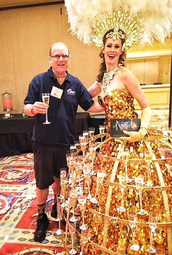 A man is holding a glass of champagne next to a woman in a gold dress