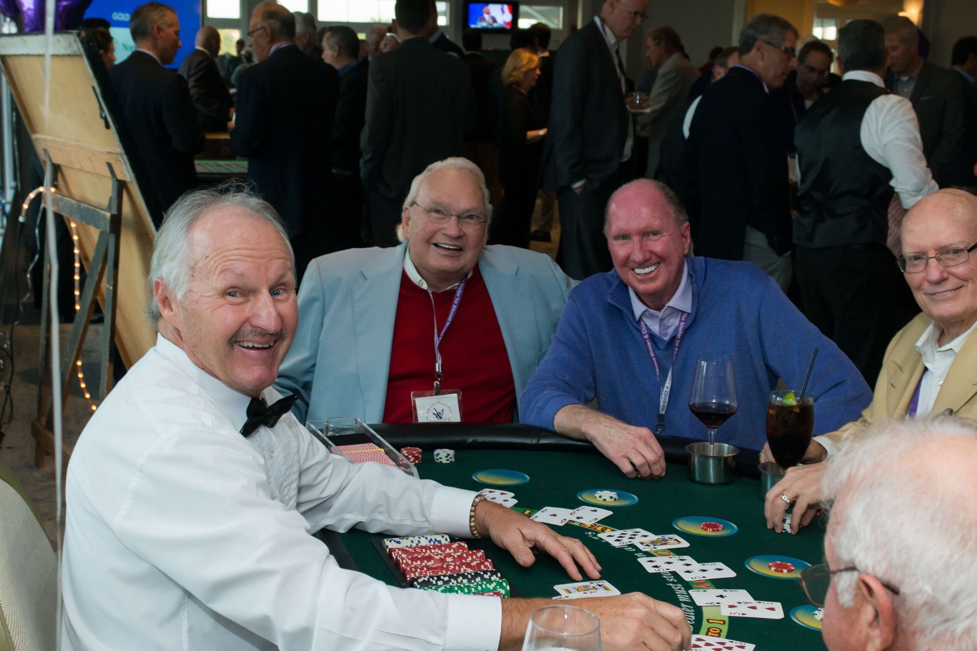 A group of men are sitting at a table playing poker