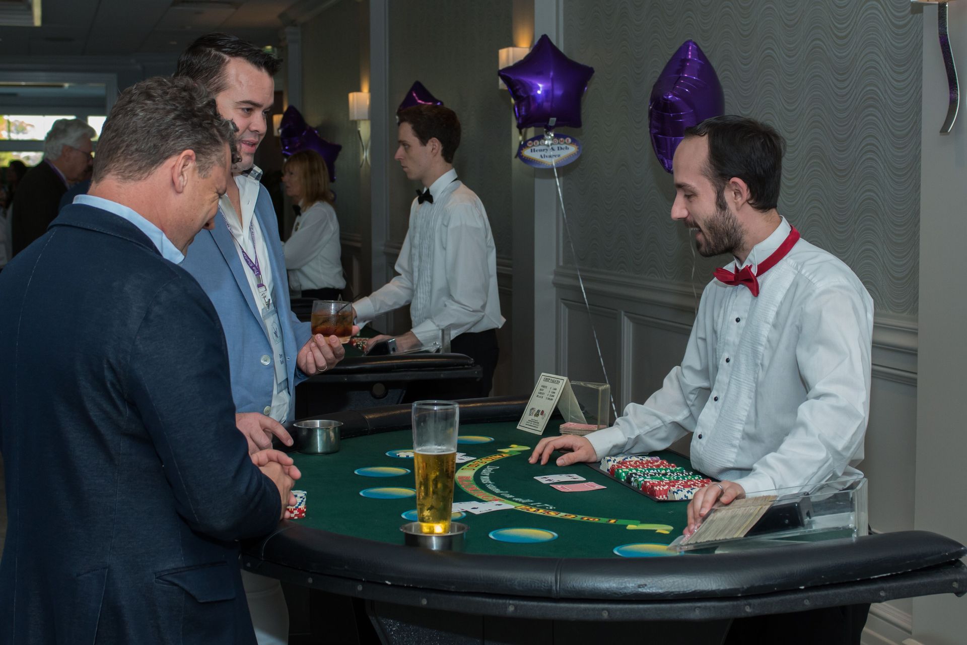 A group of men are playing a game of blackjack at a table.