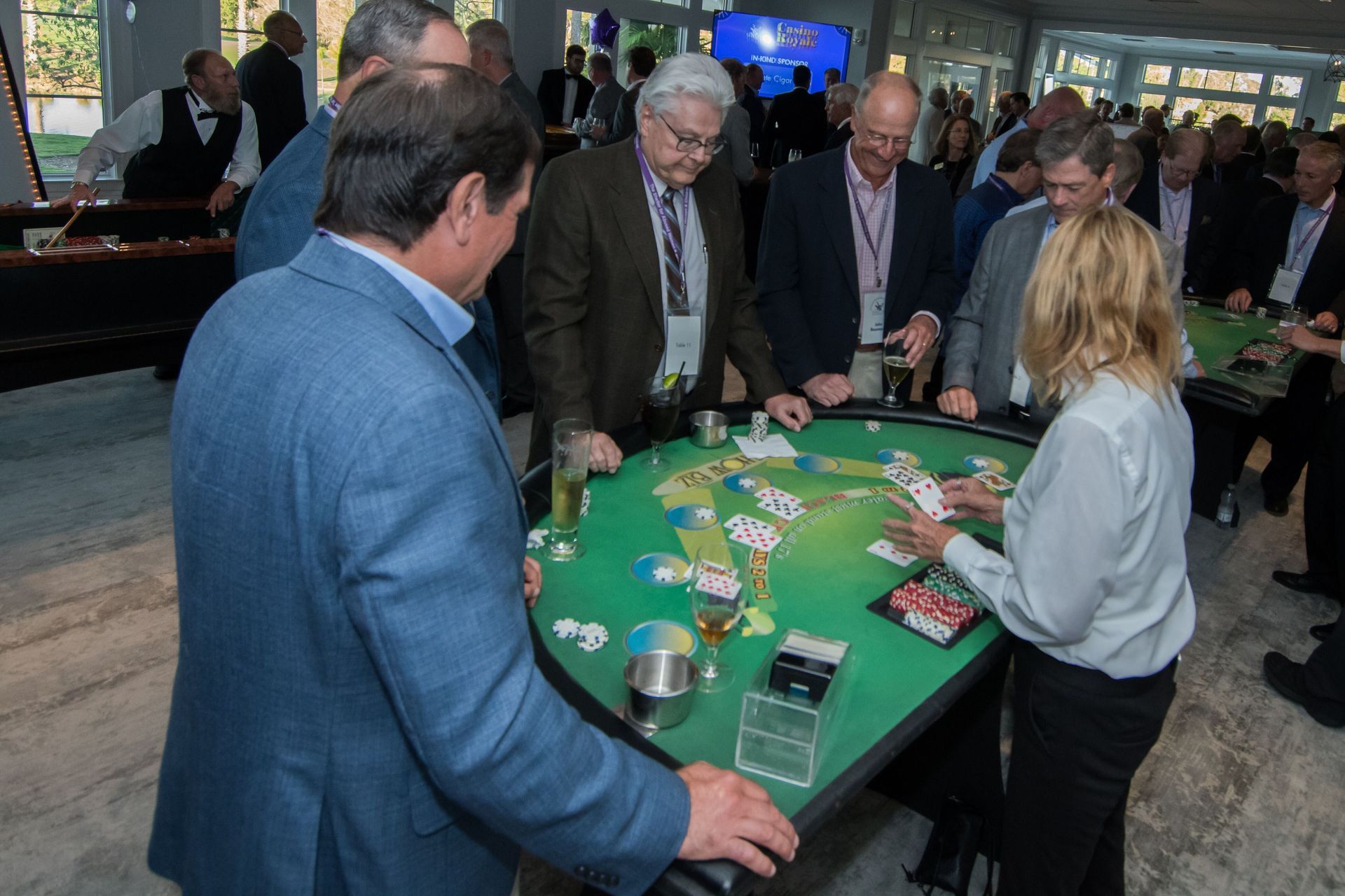 A group of people are playing a game of cards at a table.