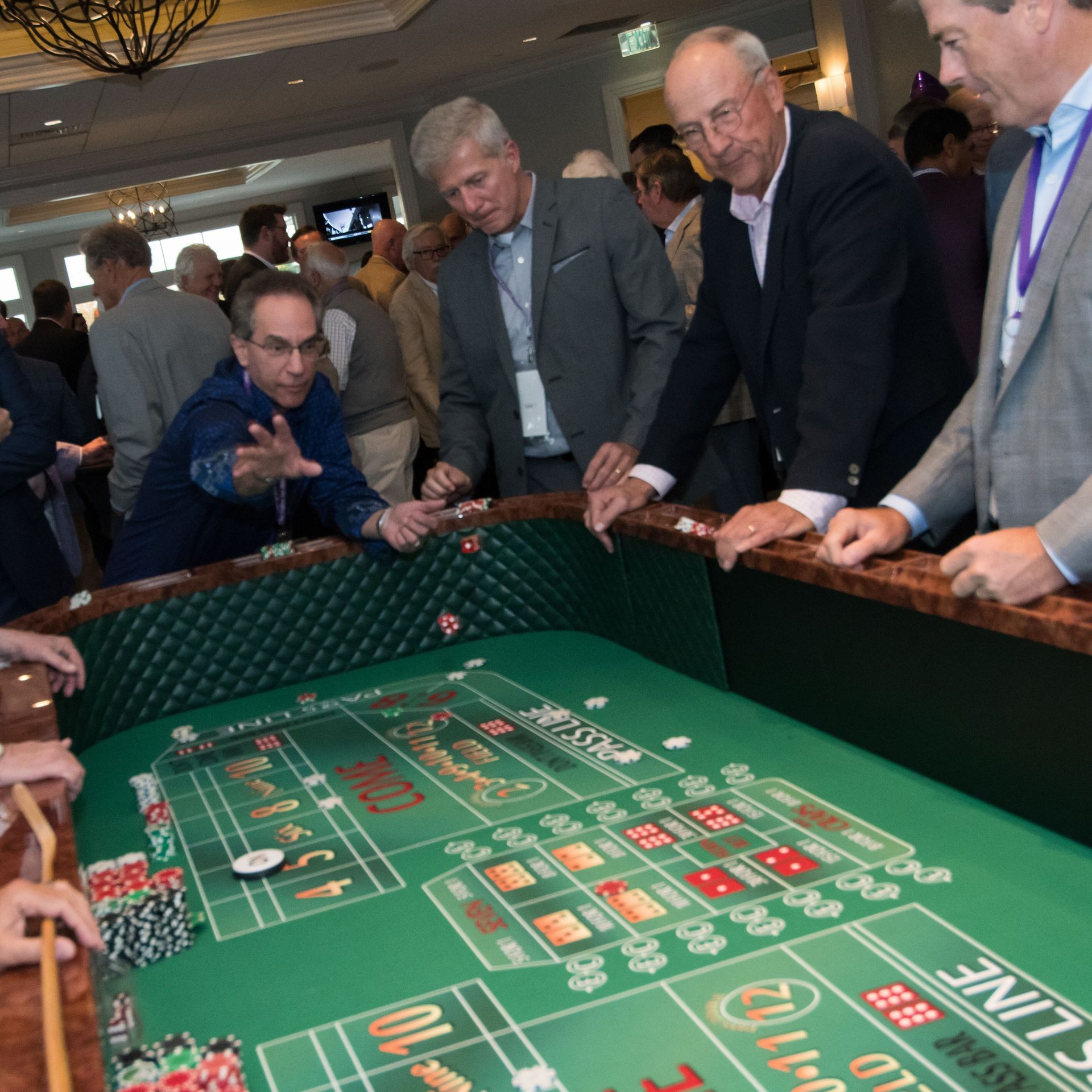 A group of men are playing a game of craps on a green table