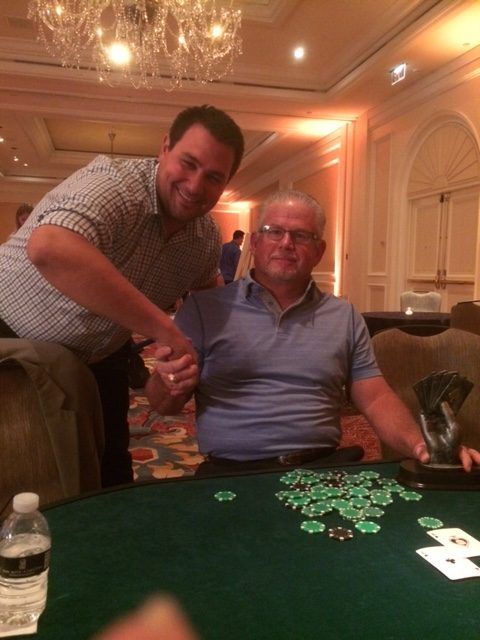 A man shaking hands with another man at a poker table