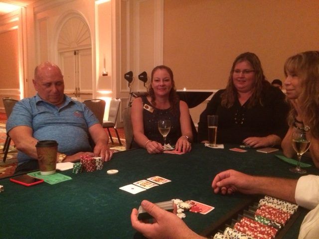 A group of people are sitting around a table playing poker