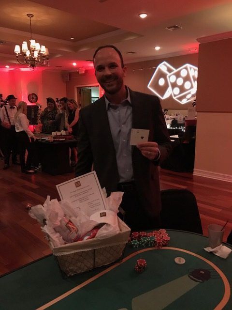 A man holding a card in front of a poker table