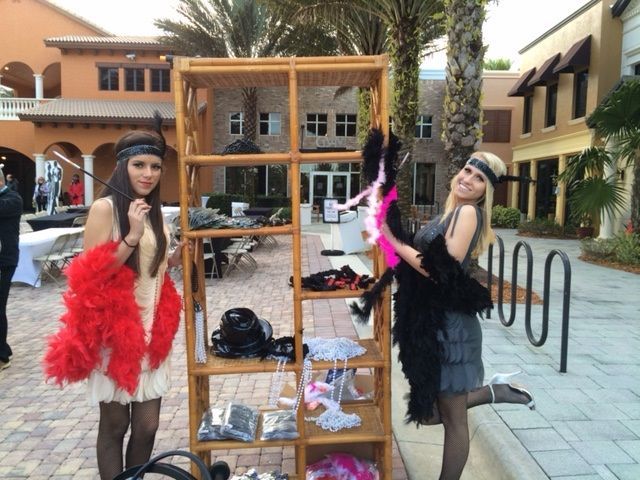 Two women standing next to each other in front of a wooden shelf