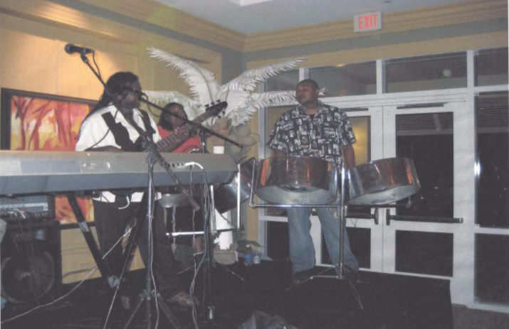 A group of people playing instruments in a room with an exit sign