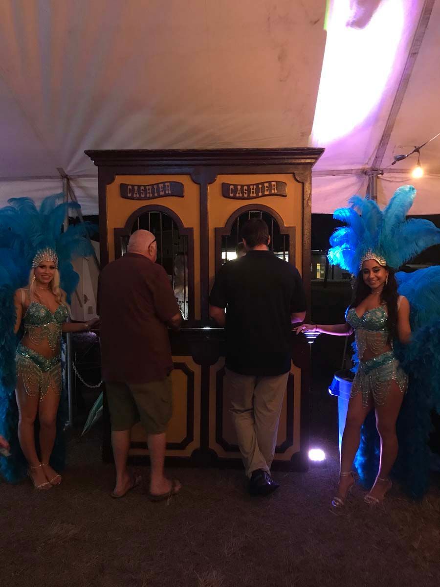 A man and two women are standing in front of a ticket booth.