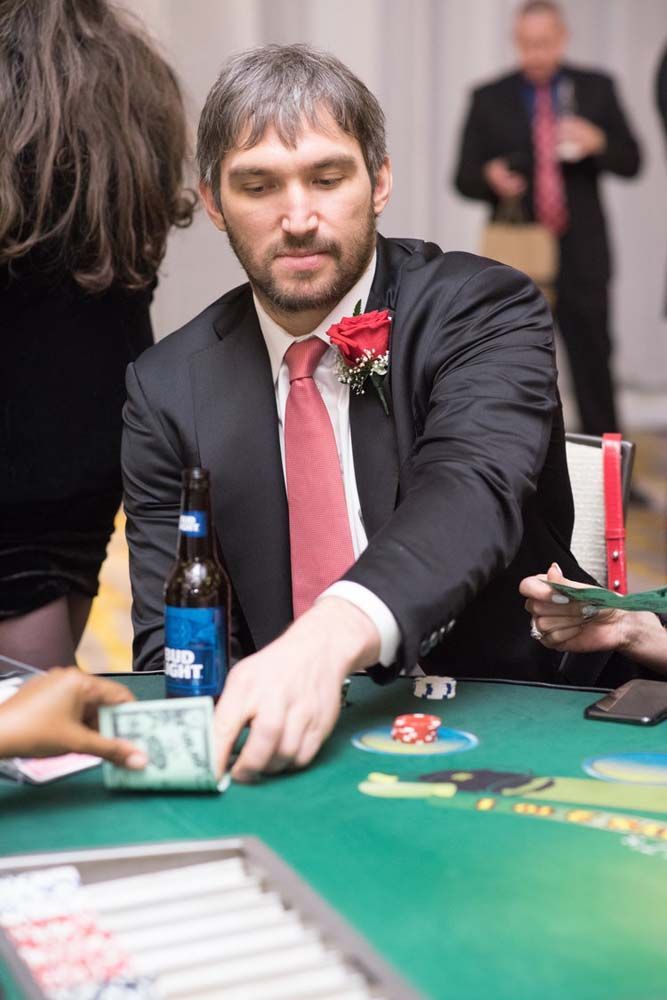 A man in a suit and tie is playing poker at a table.