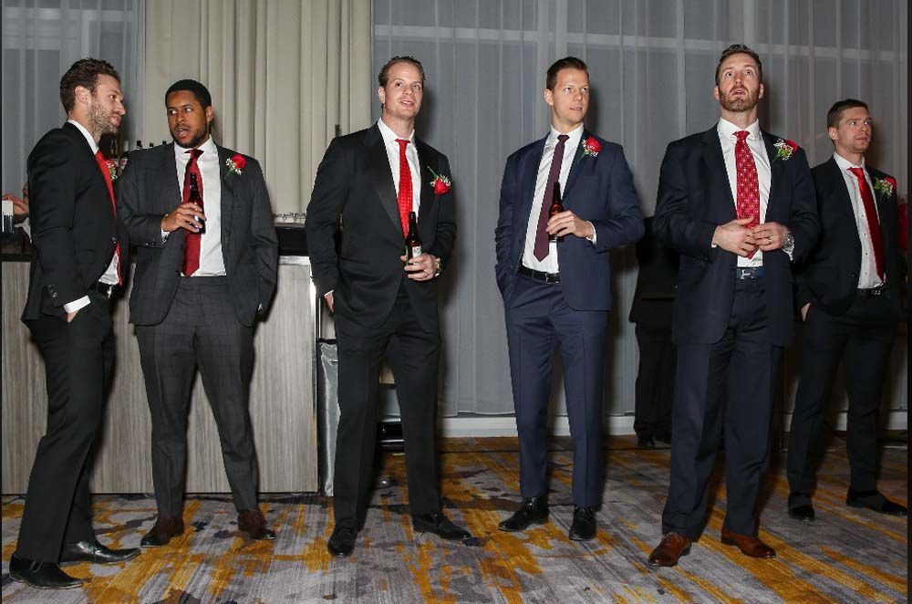 A group of men in suits and ties are standing next to each other.