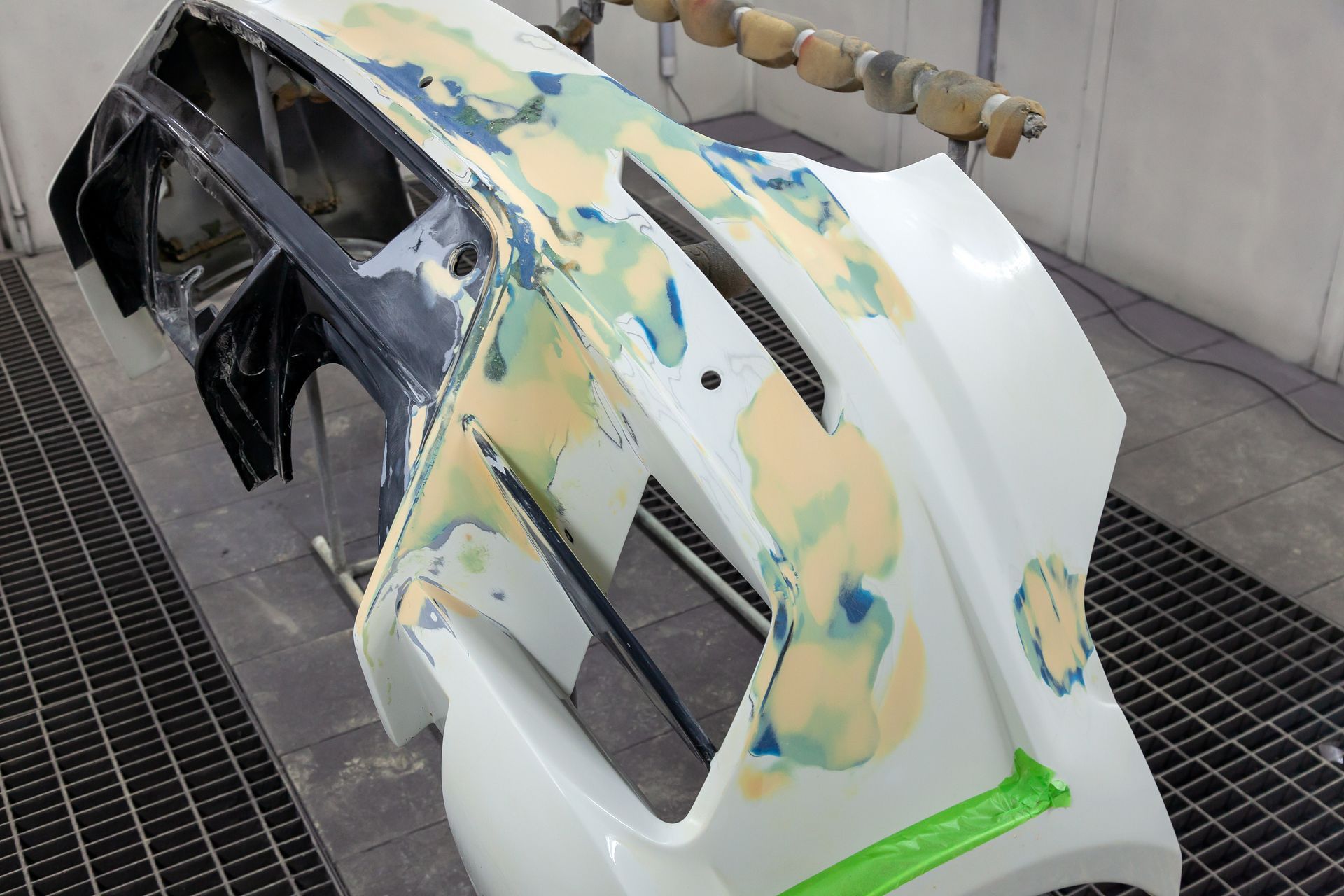 Person polishing a silver car's headlight with a power buffer. Blue tape protects surrounding areas. Person polishing a silver car's headlight with a power buffer. Blue tape protects surrounding areas.