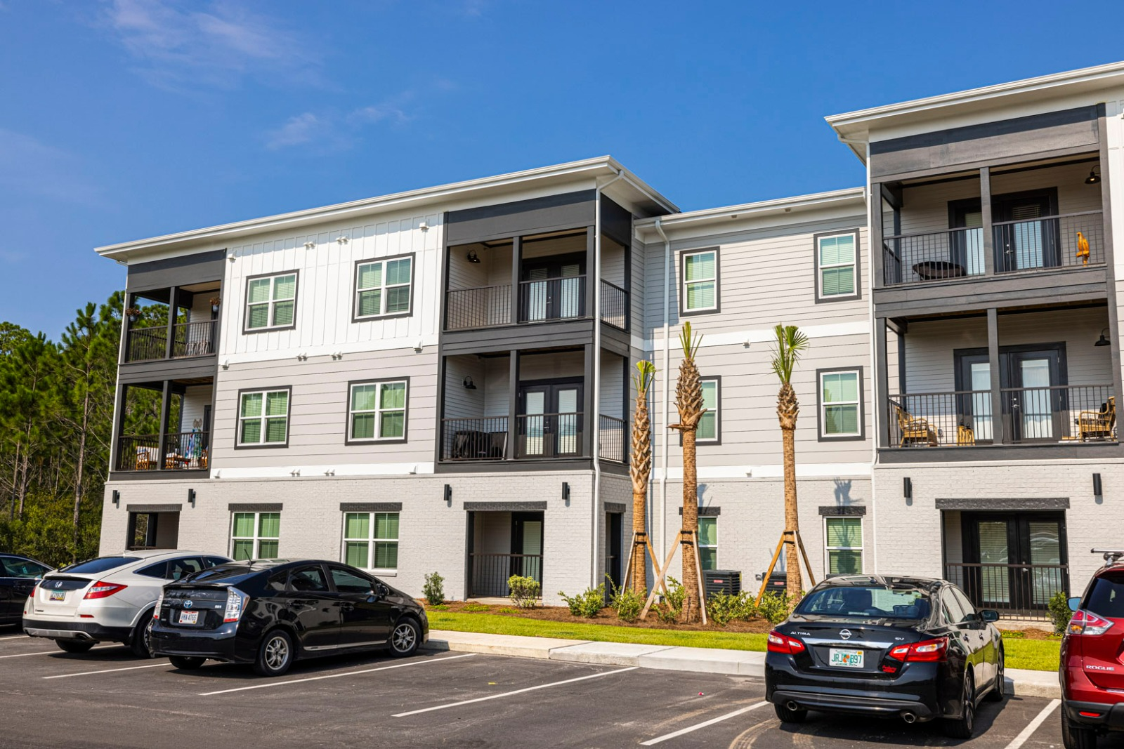A large apartment building with cars parked in front of it.