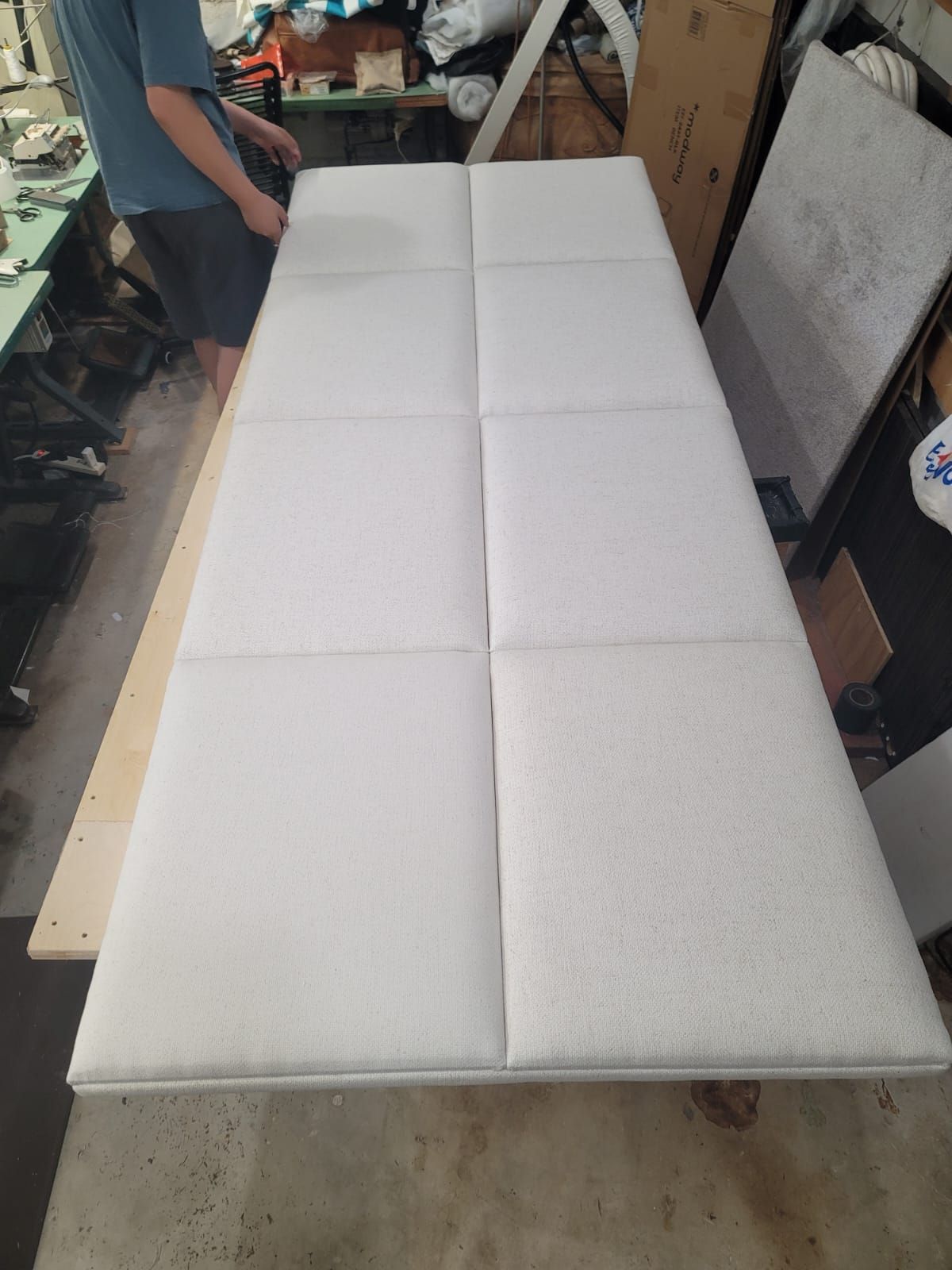 A man is standing next to a long white foam board.