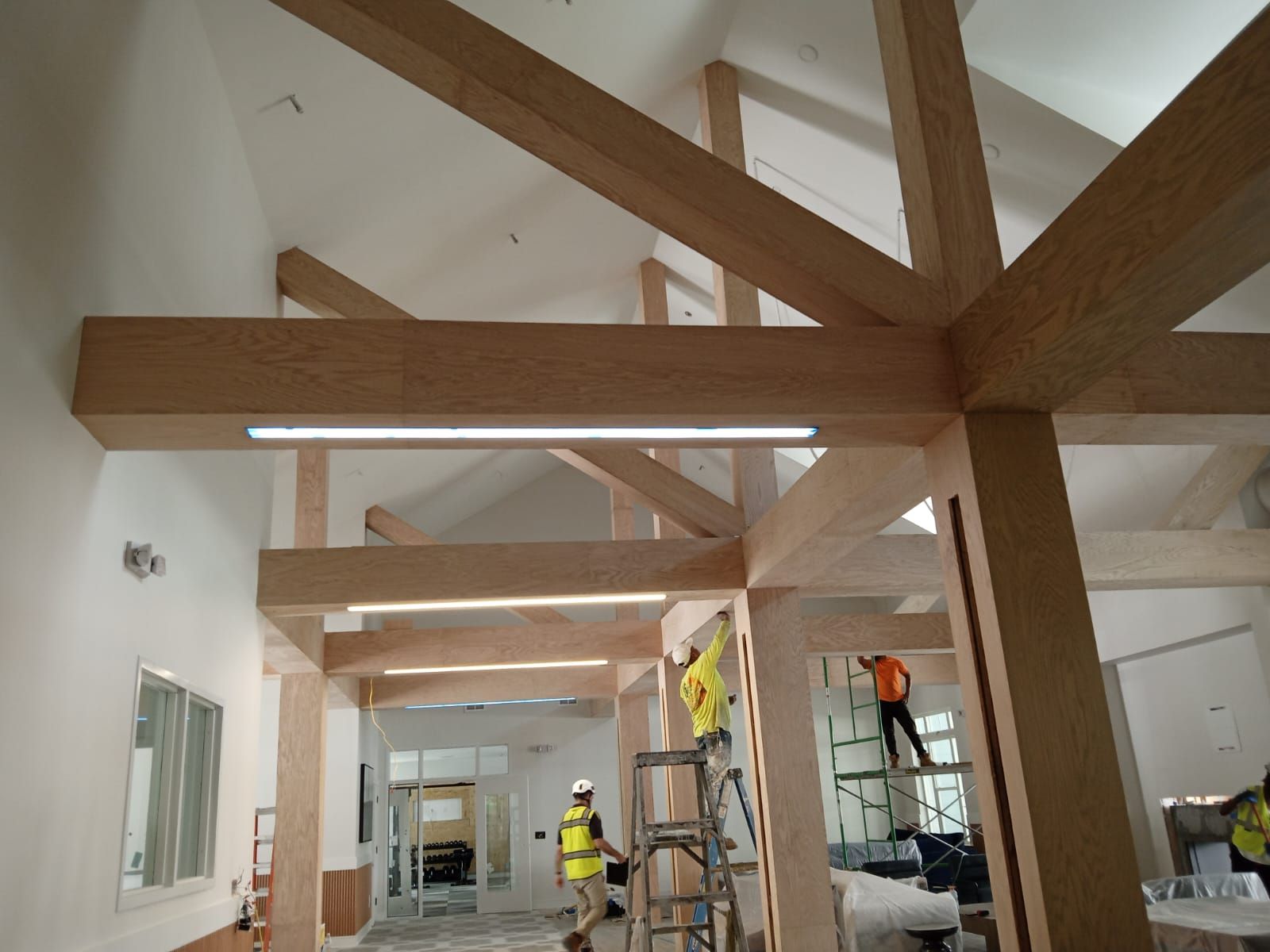 A group of construction workers are working on a large wooden structure.