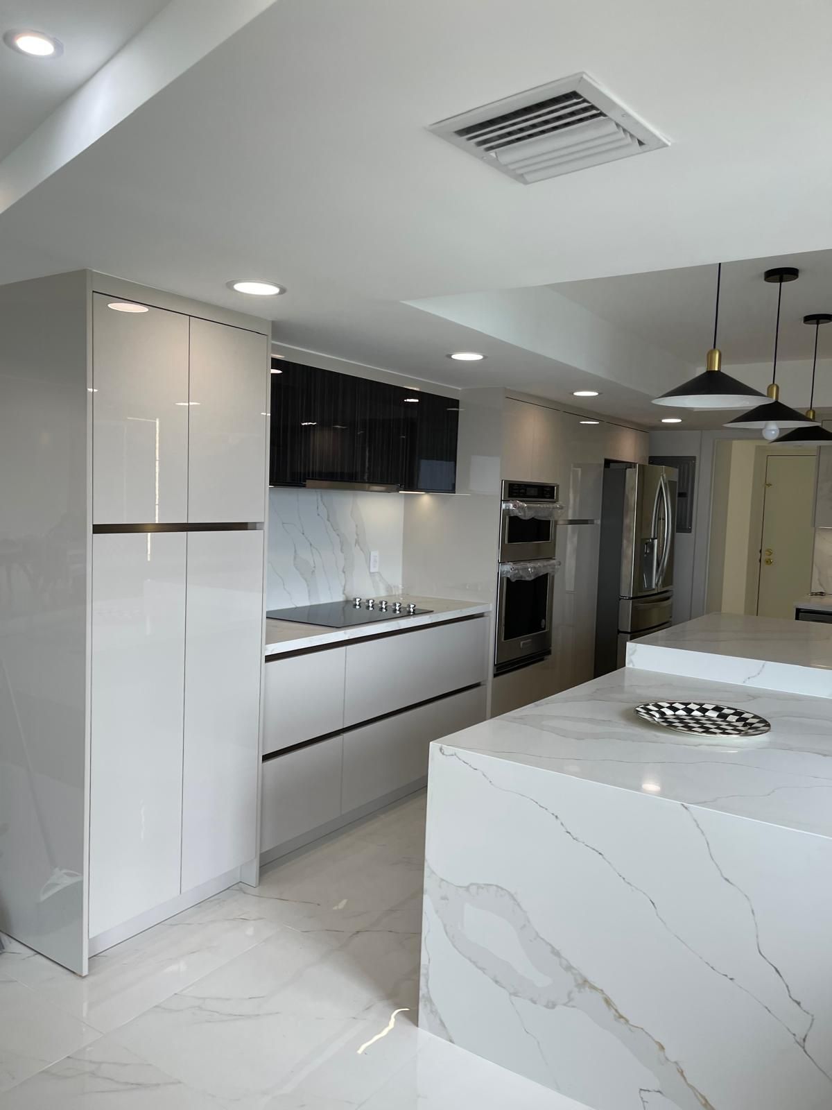 A kitchen with white cabinets and a marble counter top.