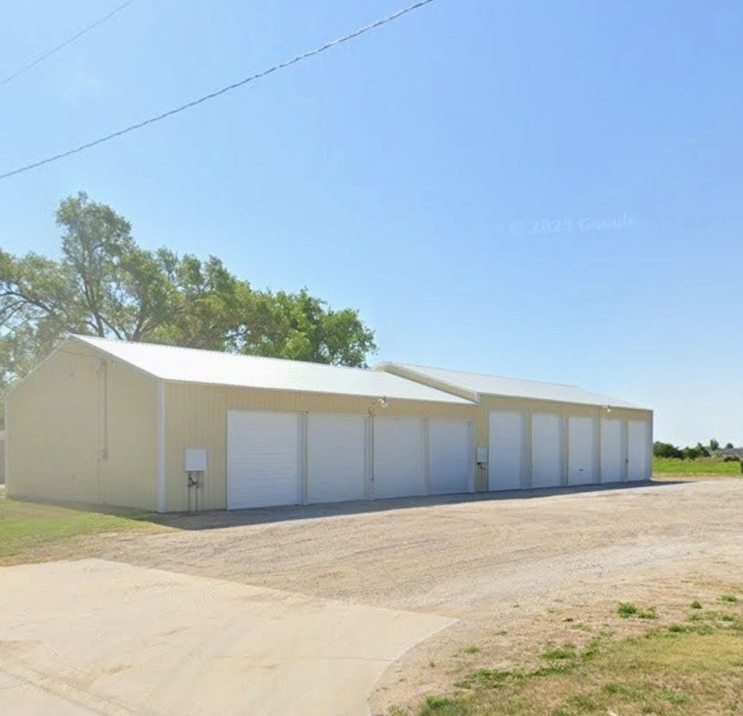 Beige storage units with white doors under a clear, blue sky.