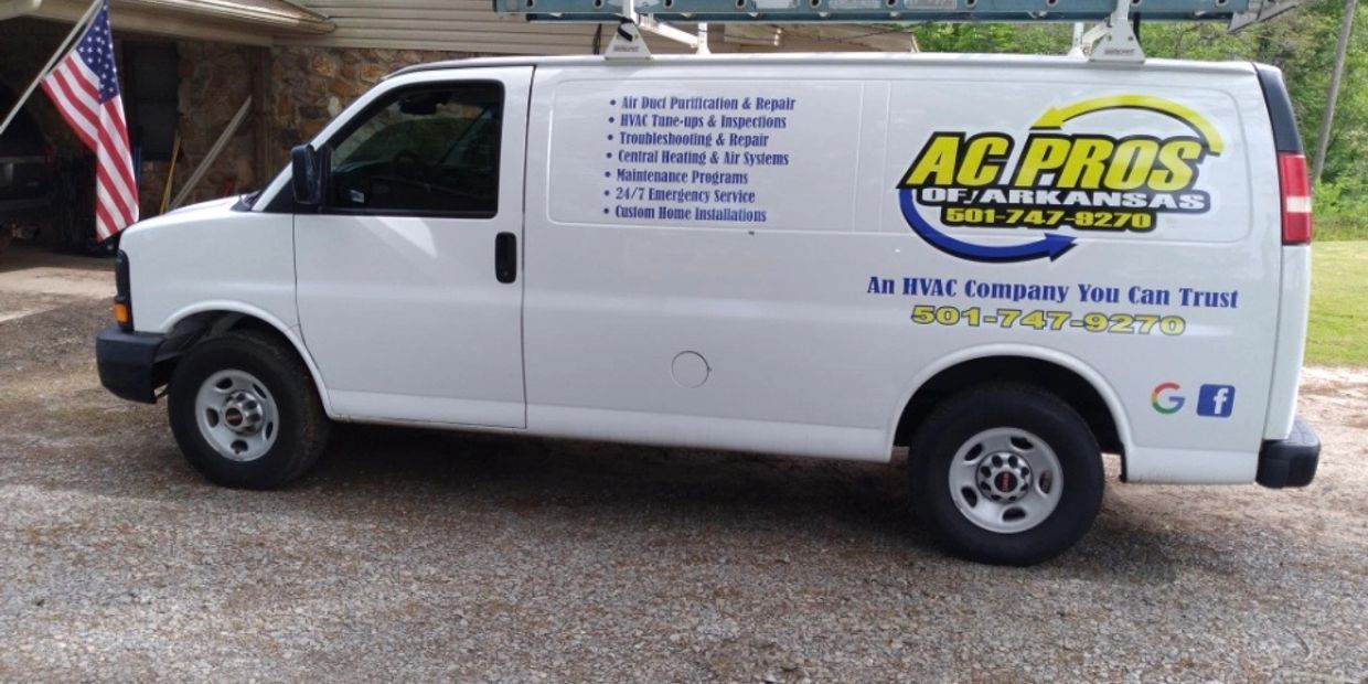 A white van with the word acpros on the side is parked in front of a garage.