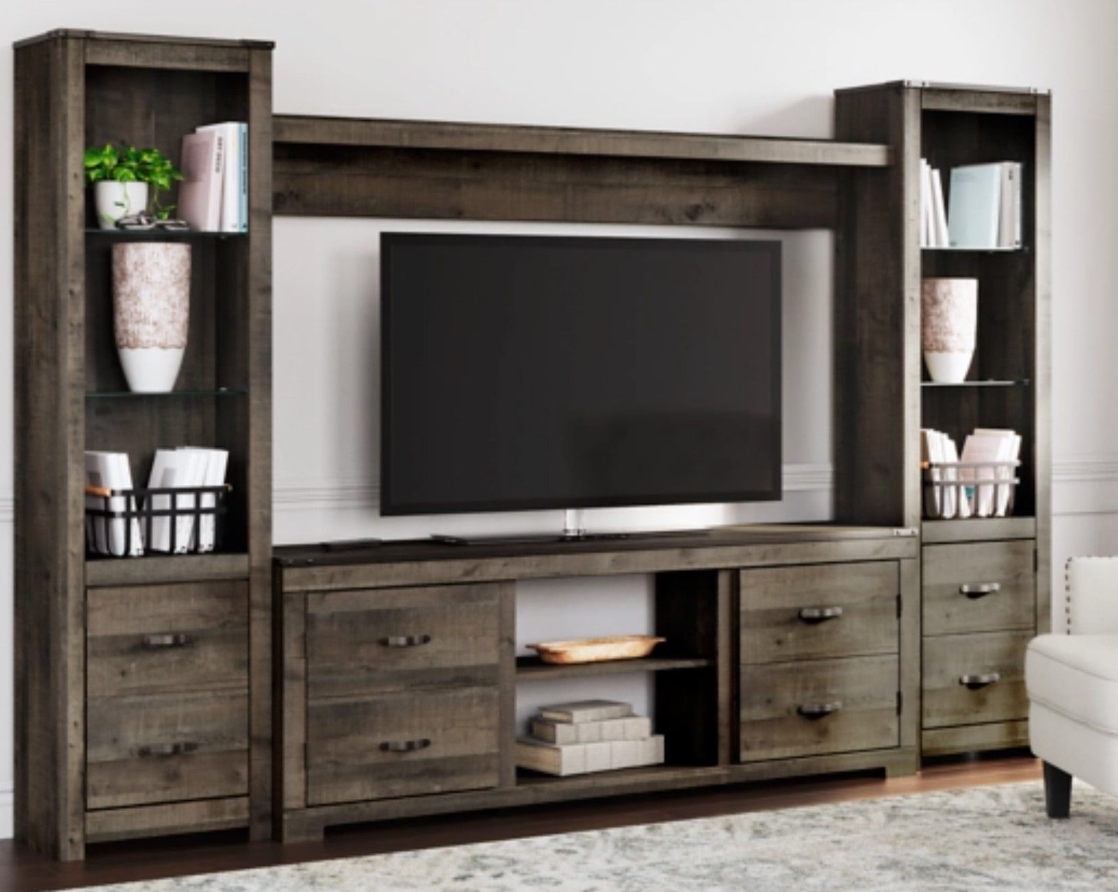 Wooden entertainment center with a mounted TV, shelves, and cabinets.