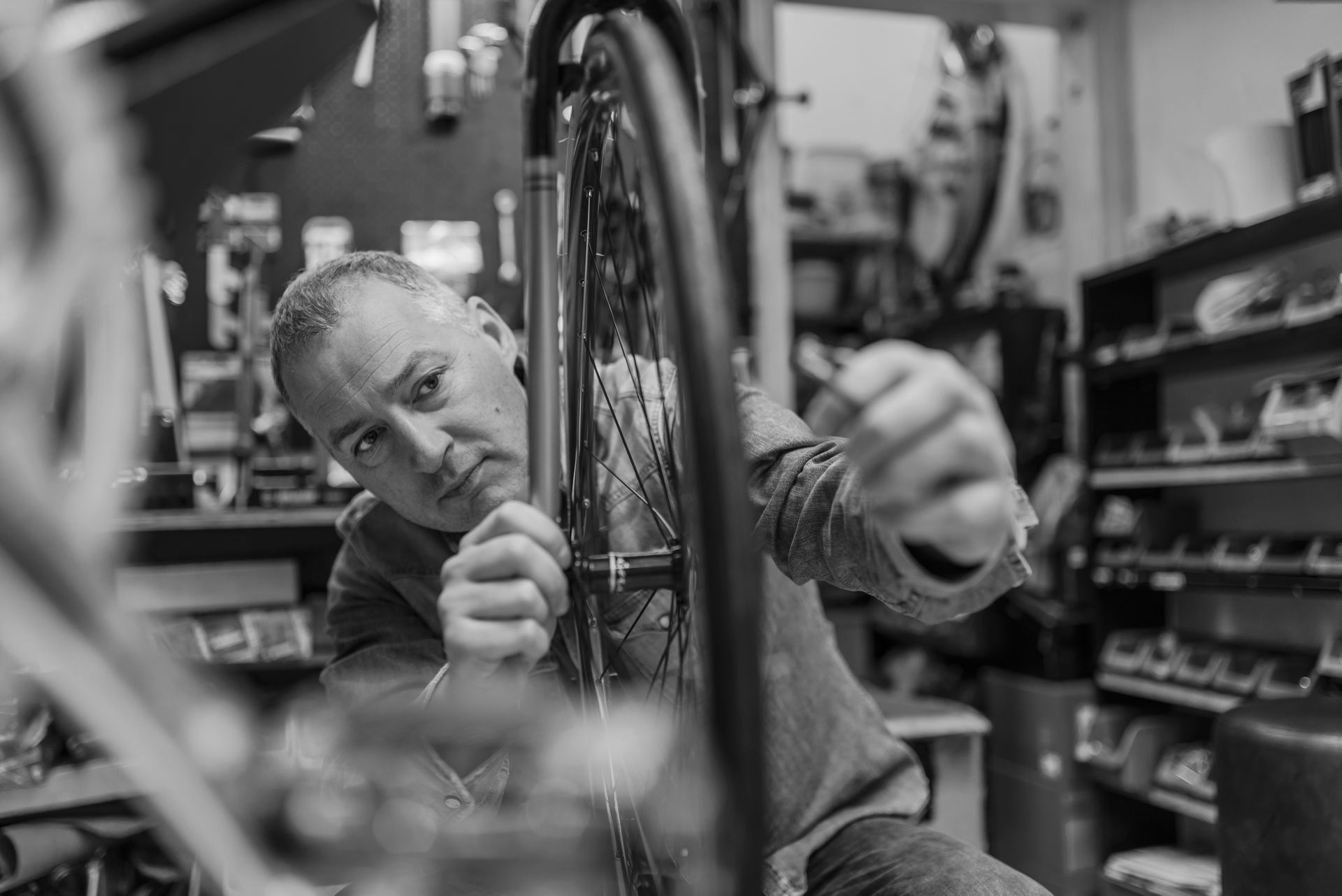 A bike shop owner repairing a bicycle, the owner needs small business tech support