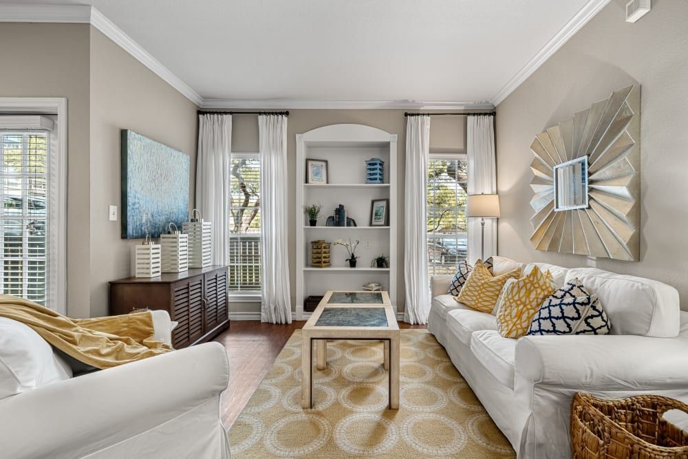 a living room with two couches, a coffee table, and a bookshelf at Marquis at Deerfield in San Antonio, TX.