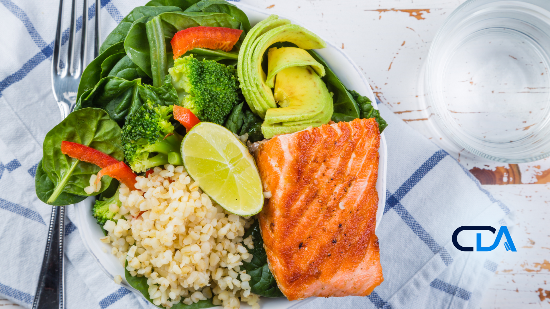 A plate of food with salmon , rice , broccoli and avocado on a table.