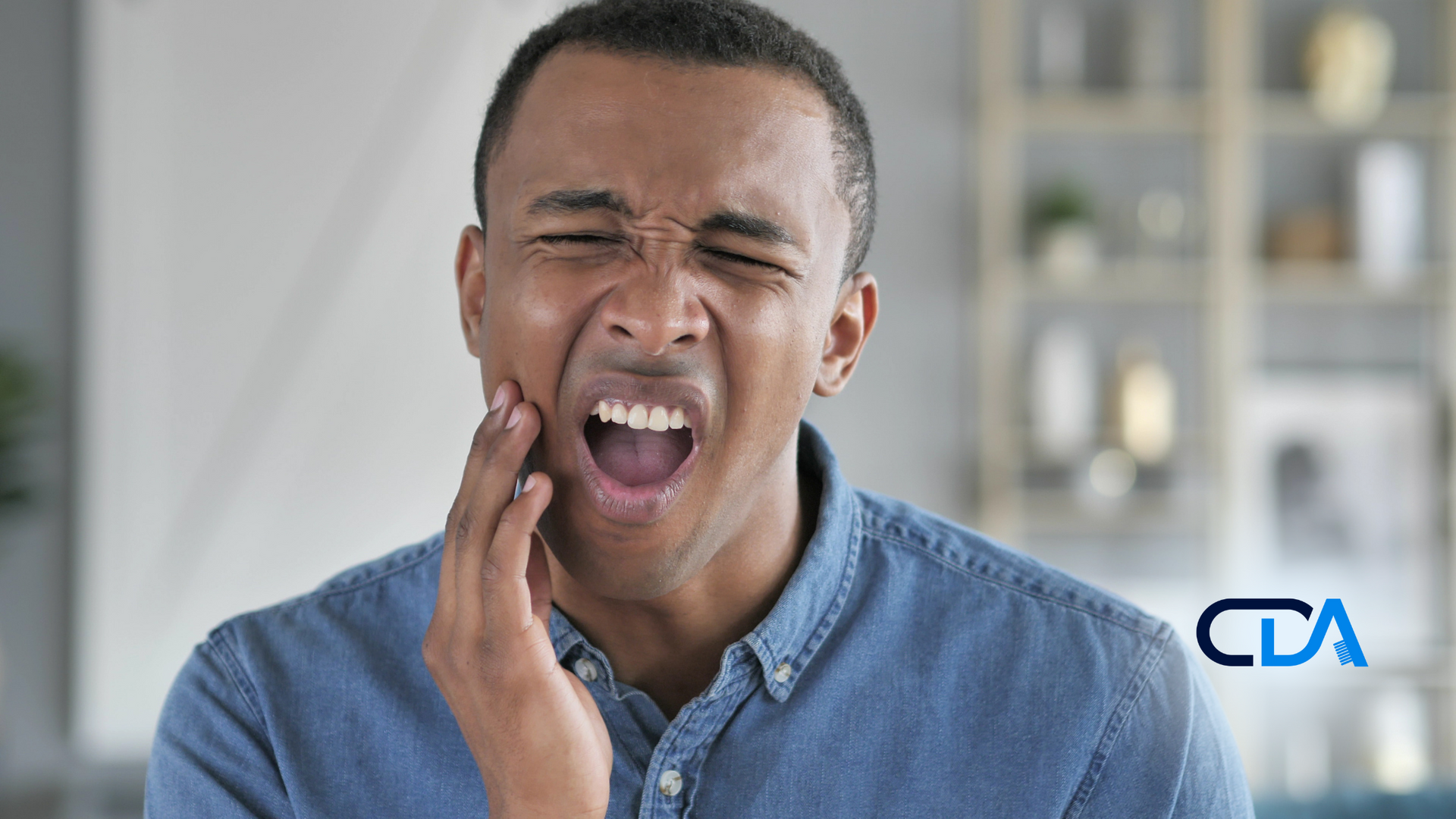 A man is holding his face in pain because of a toothache.