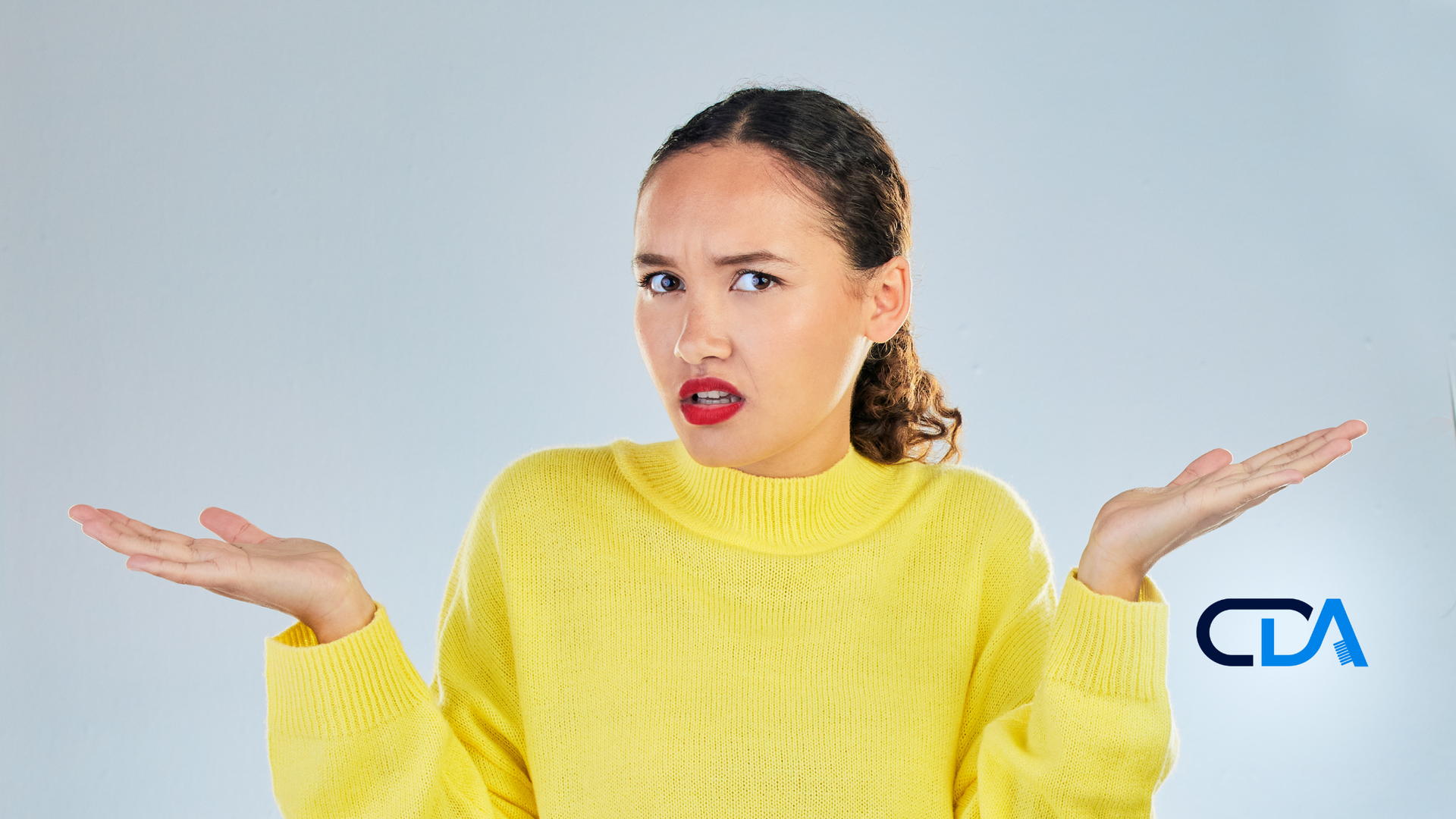 A woman in a yellow sweater is shrugging her shoulders.