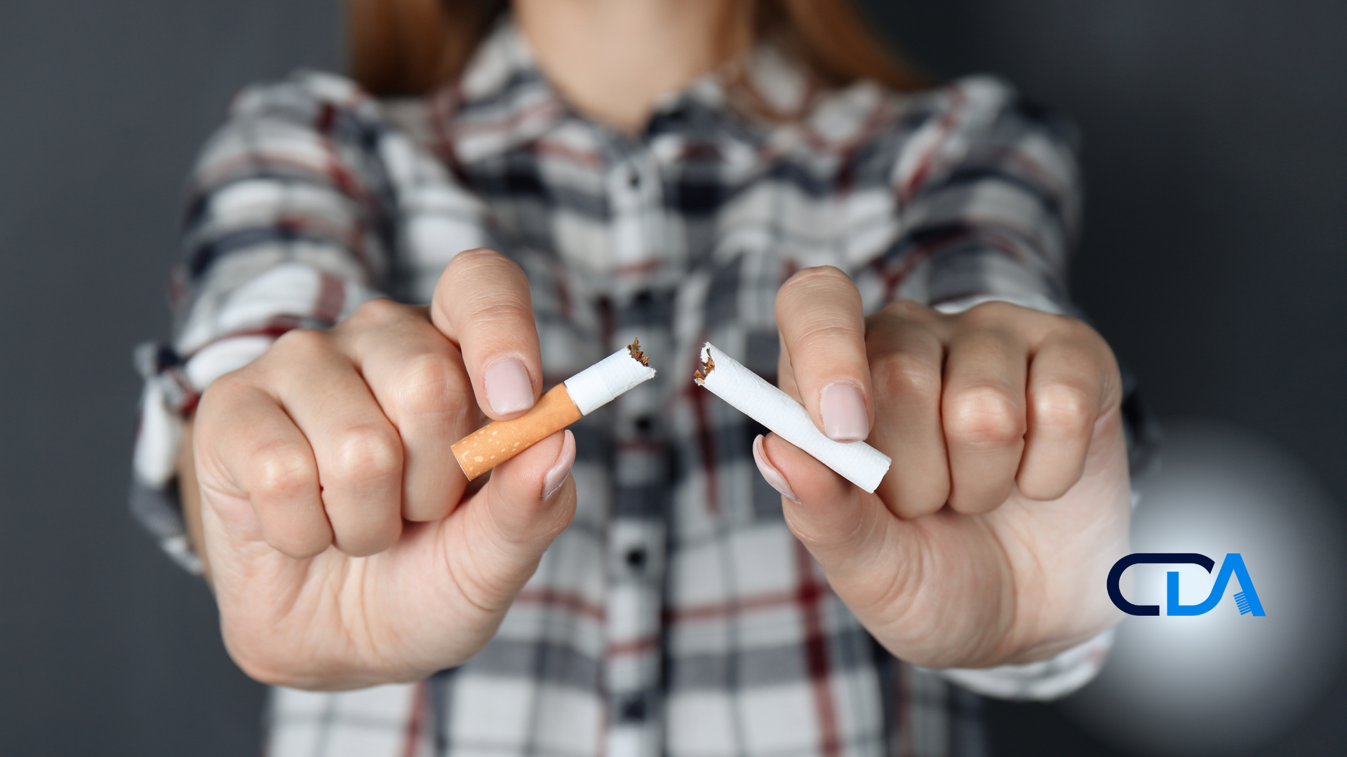 A woman is holding two broken cigarettes in her hands.