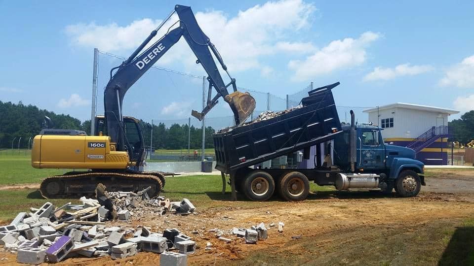 An excavator is loading dirt into a dump truck.