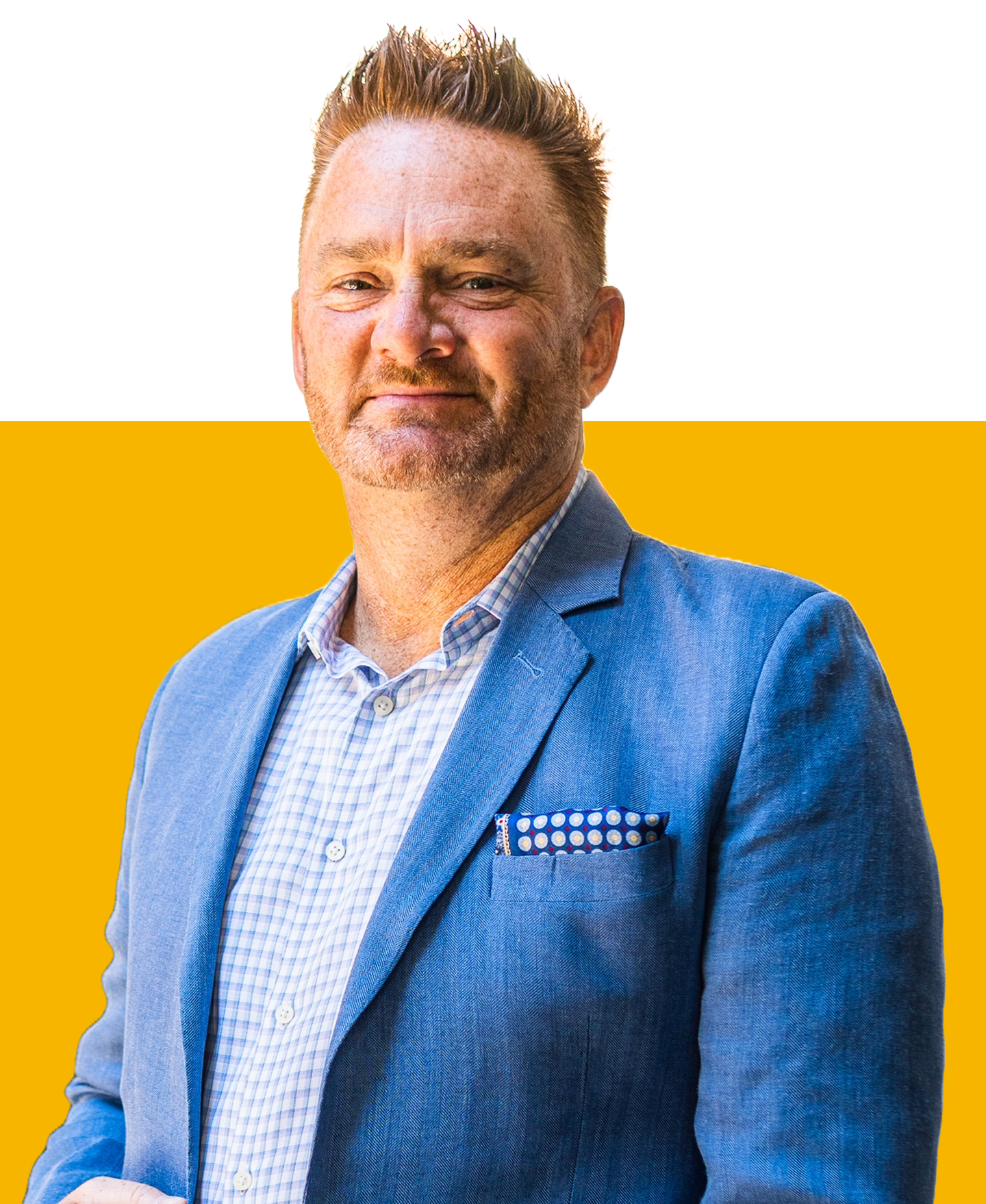 A person wearing a blue blazer and patterned shirt stands against a bright yellow background.