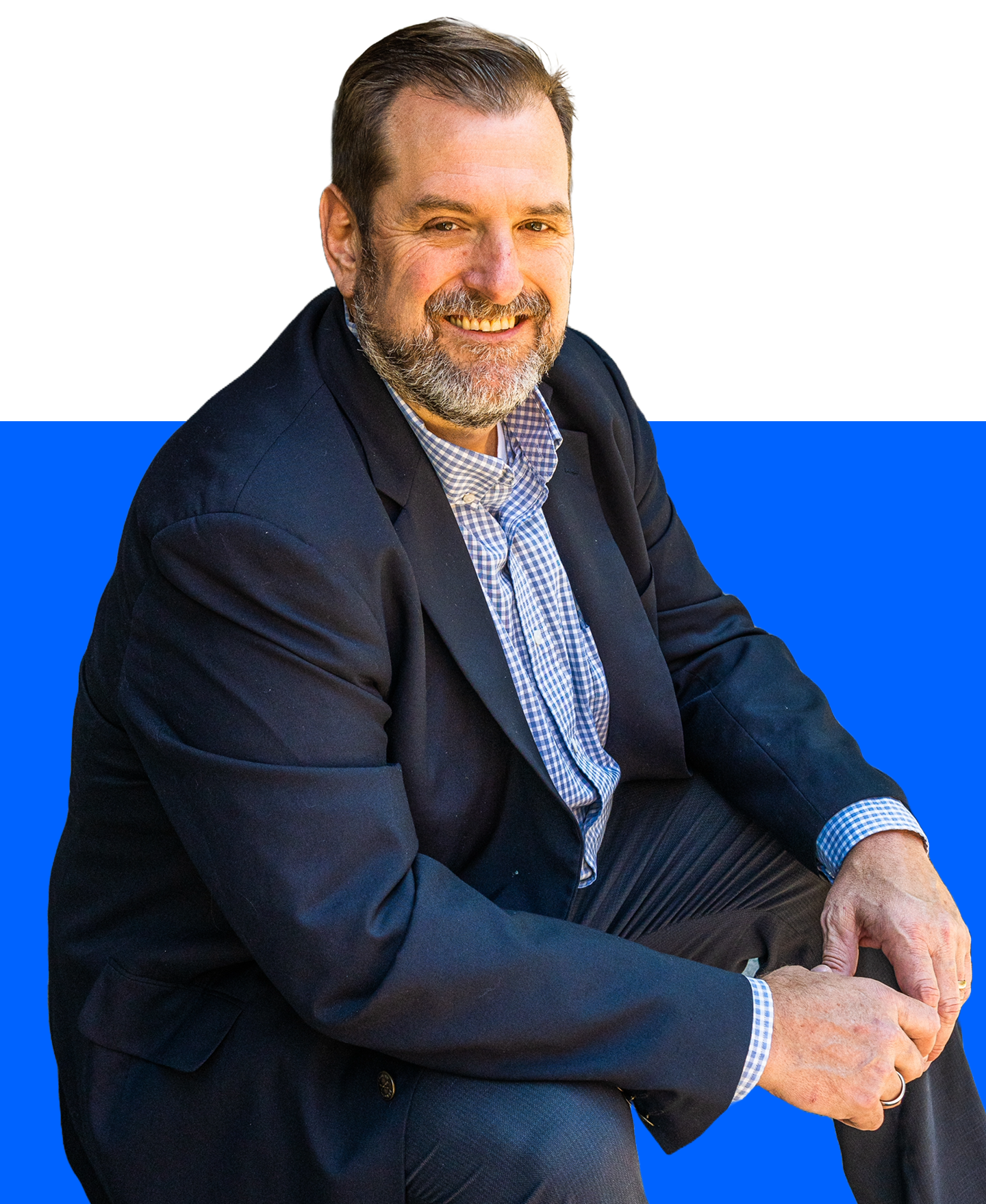 A smiling professional wearing a navy blazer and light patterned shirt, posing against a white and bright blue background.