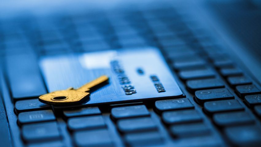 Gold key and credit card on a laptop keyboard, representing online security.