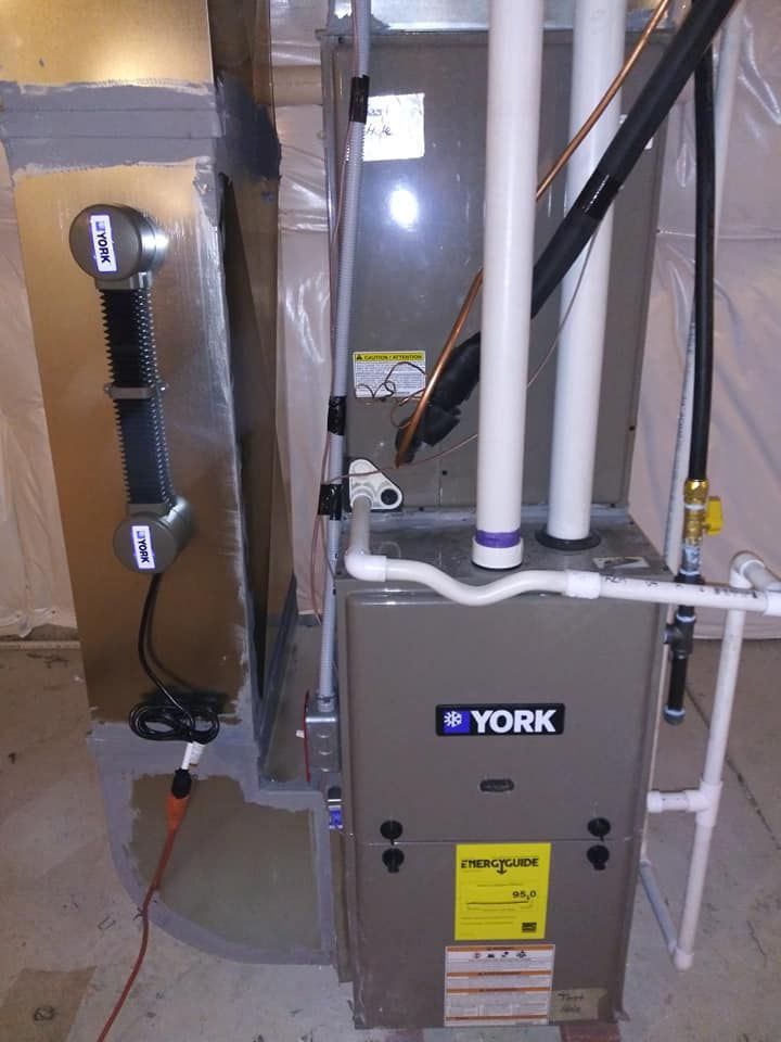 A York furnace in a utility room with ductwork, piping, and electrical components.