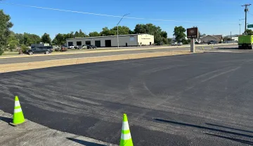 Two traffic cones are sitting on the side of a road.