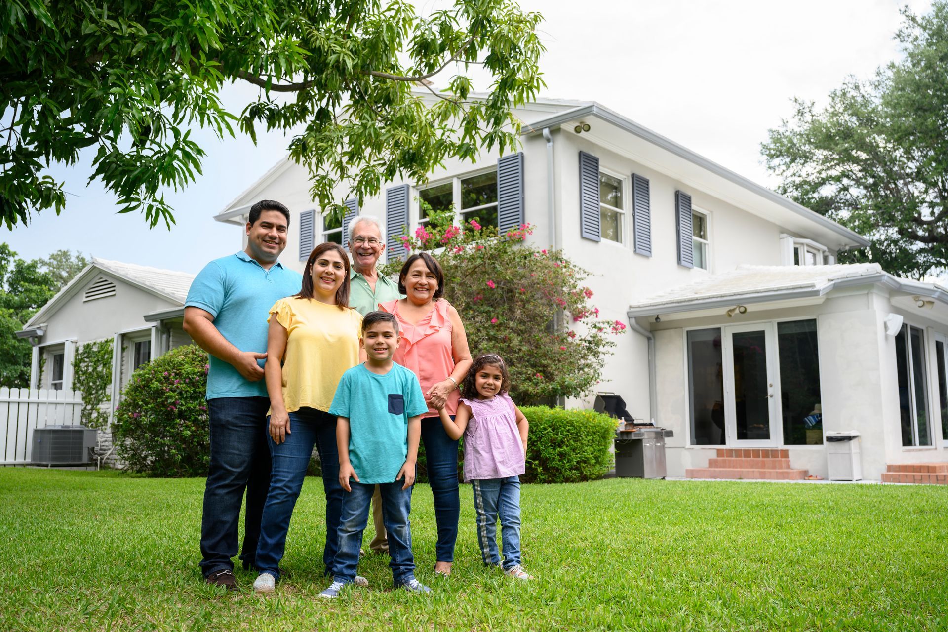 Picture of a family posing in front of their house.