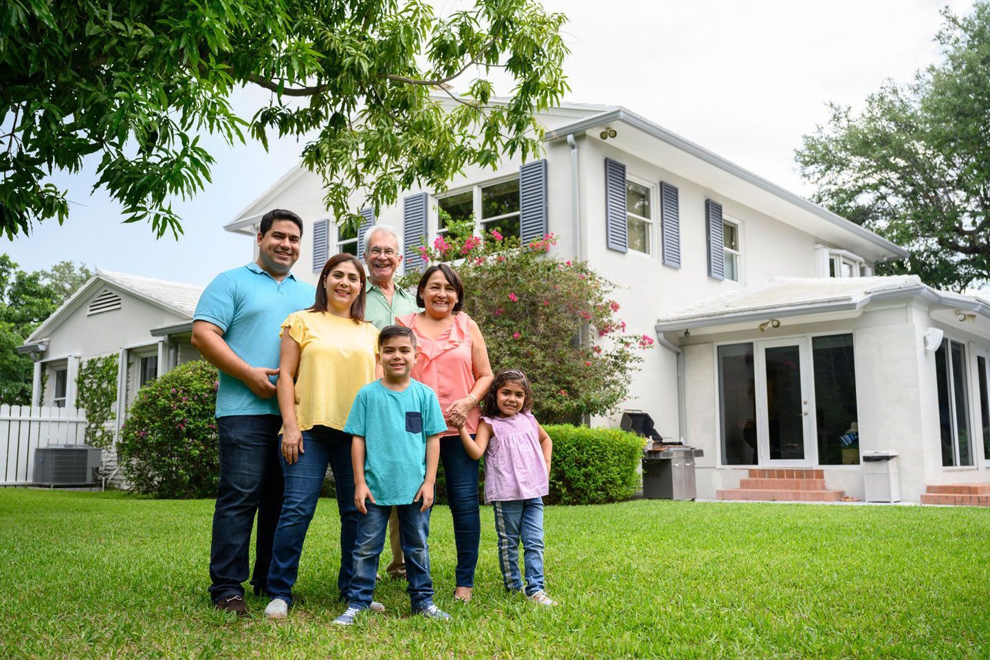 Picture of a family posing in front of their house.