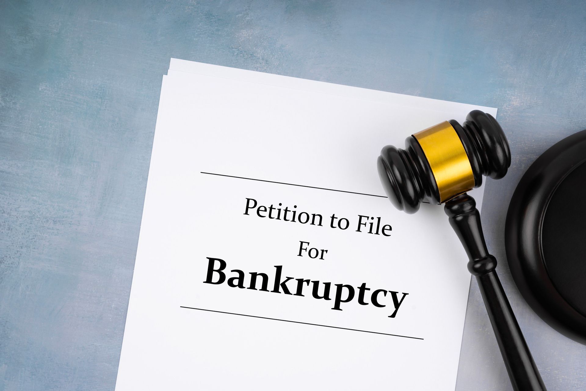 Bankruptcy petition document with judge's gavel on blue background.
