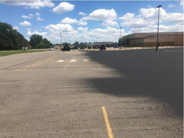 An empty parking lot with a building in the background