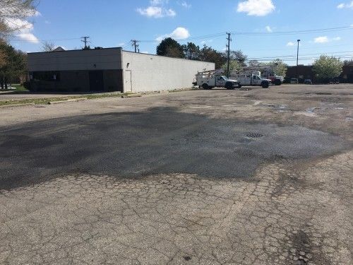 A parking lot with trucks parked in front of a building