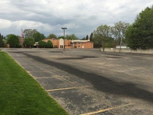 An empty parking lot with a building in the background