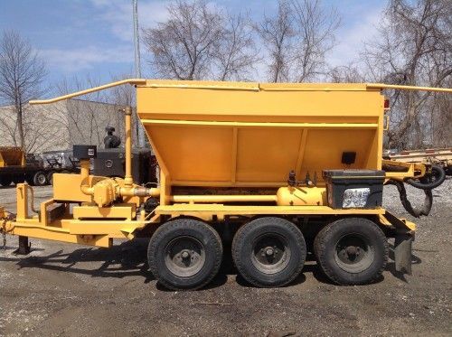 A yellow trailer with three tires is parked in a parking lot