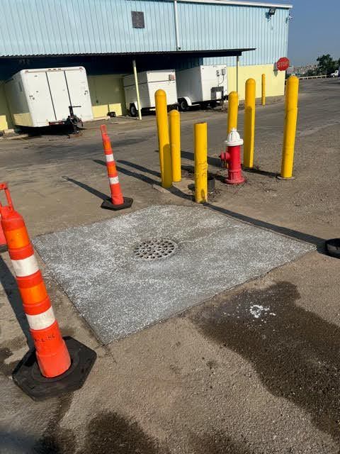 A red fire hydrant is in the middle of a parking lot