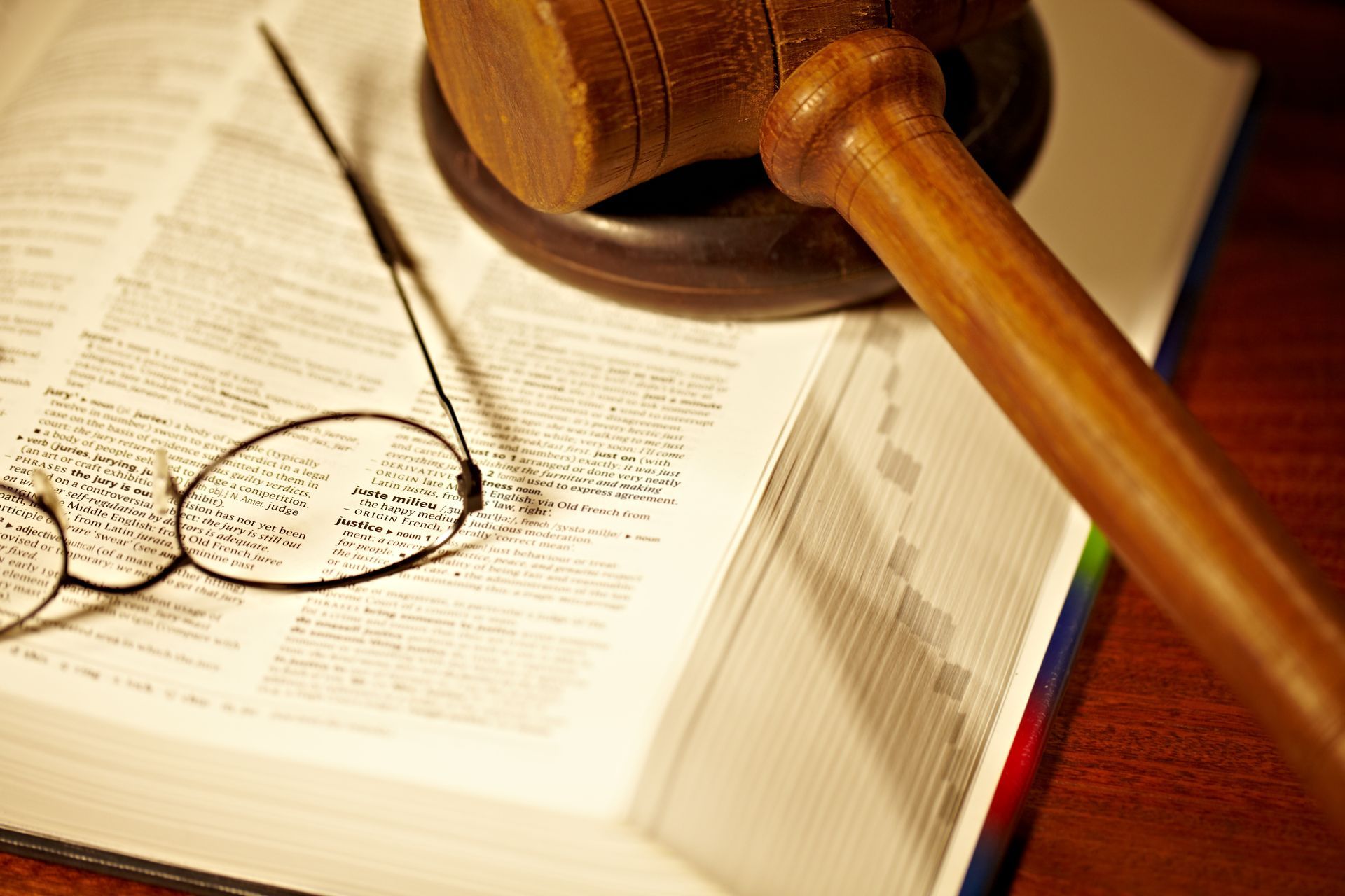 Gavel resting on an open law book with reading glasses, symbolizing justice and legal authority in court order breach cases under Section 127(1) of the Criminal Code.