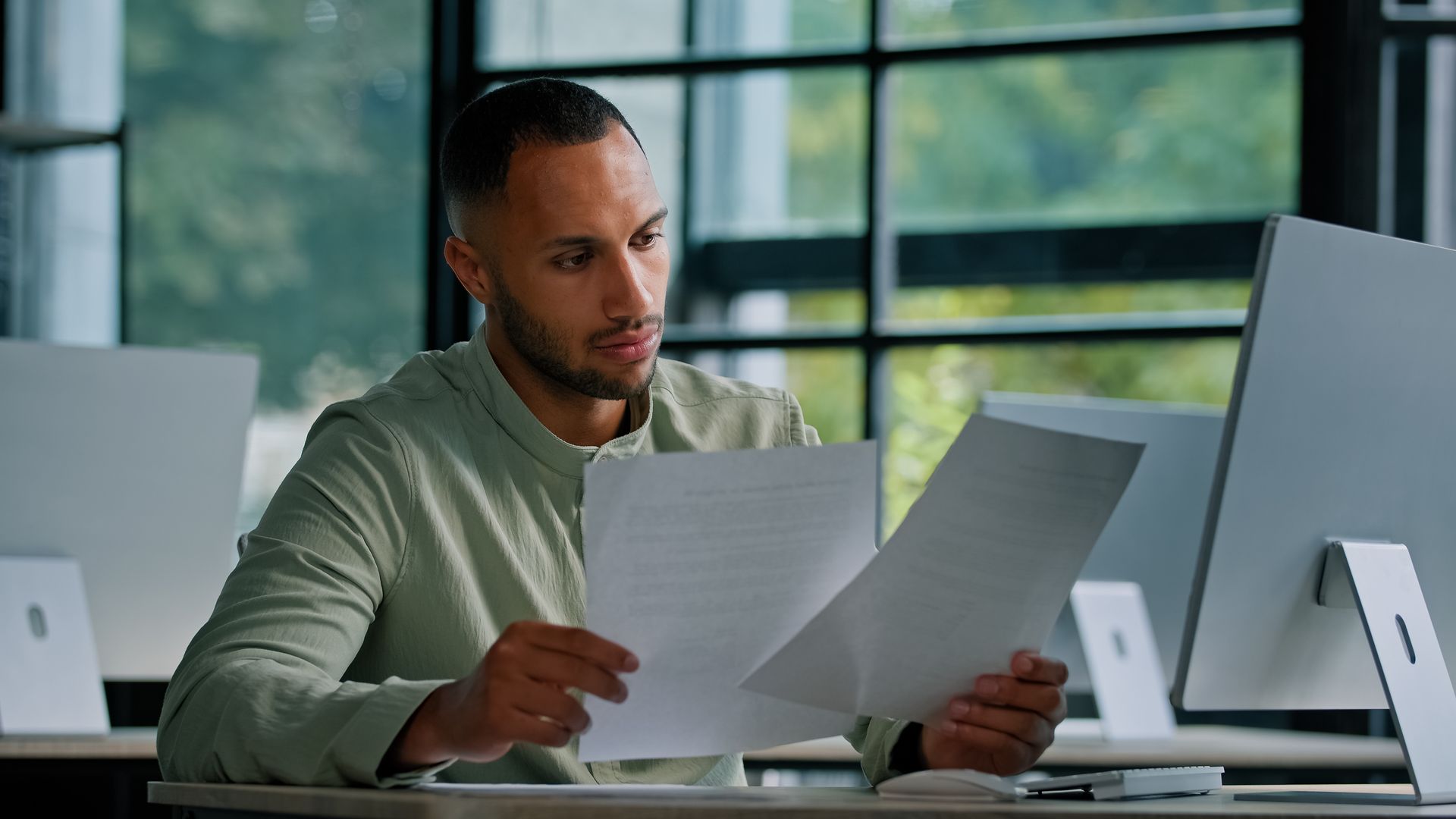 Concerned man reading documents in an office — representing the lasting impacts of a criminal record from a drug-impaired driving conviction.