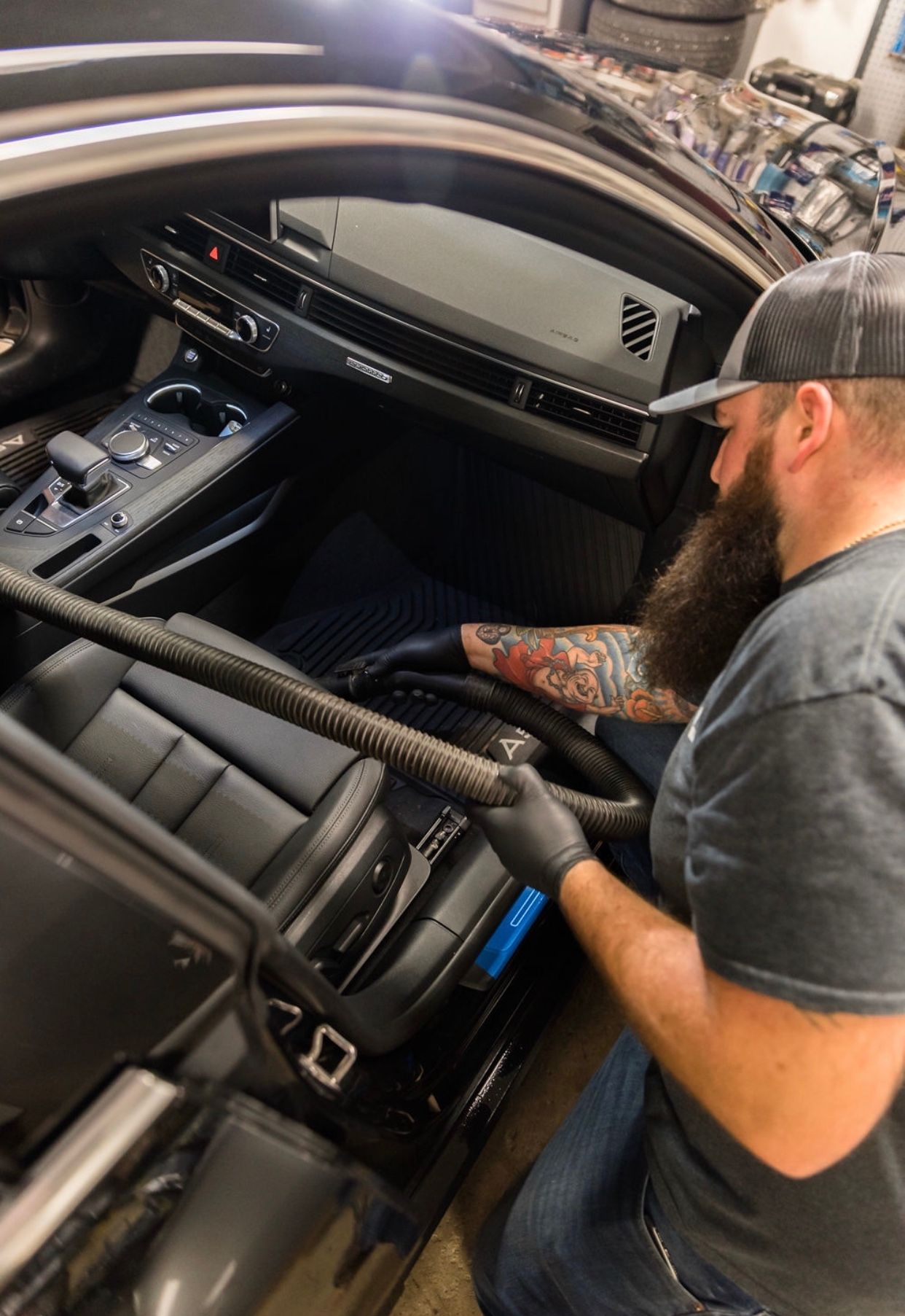 Black leather BMW steering wheel with the BMW logo and wooden dashboard accents.