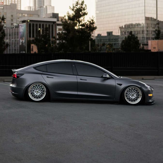 Black car door with a heart-shaped sticker; blurry background of trees.